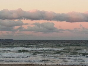 Una playa con olas y un cielo nublado.