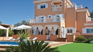 A multi-story building with balconies, a swimming pool, and outdoor seating. - Cozy home in Lluchmajor (Lluchmajor)