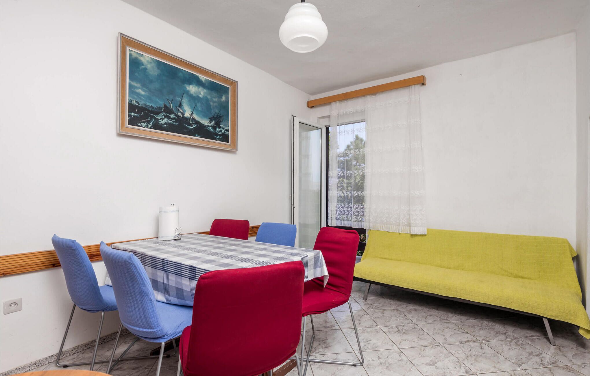 A dining area with a table, chairs, and a sofa.
