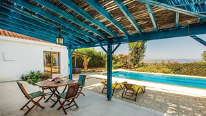 A covered outdoor area with a pool, a table with chairs, and a pergola structure. - Stunning home in Argaka with WiFi (Argaka)