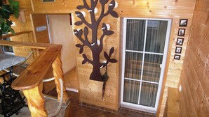 Een houten interieur met een wanddecoratie in de vorm van een boom, een houten bank en een betegelde vloer.