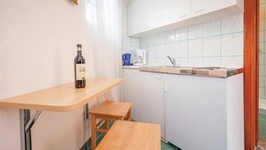 A compact kitchen with white cabinets, a sink, and a coffee maker. - Cozy apartment in Crikvenica with WiFi (Crikvenica)