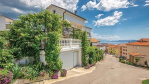 A residential street with houses, a clear sky, and a distant view of mountains. - Cozy apartment in Crikvenica with WiFi (Crikvenica)