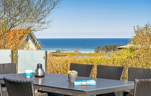 Comedor con mesa y sillas con vista a la playa y al océano.