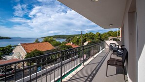 A balcony with a view of a lake and distant hills, a paved walkway, and outdoor furniture. - Pet friendly home in Nova (Nova)