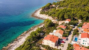 A coastal residential area with houses, clear turquoise waters, and dense greenery. - Pet friendly home in Nova (Nova)