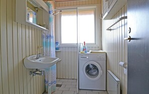 A compact bathroom with a sink, a washing machine, and a window. - 4 bedroom gorgeous home in Fanø (Fanø)