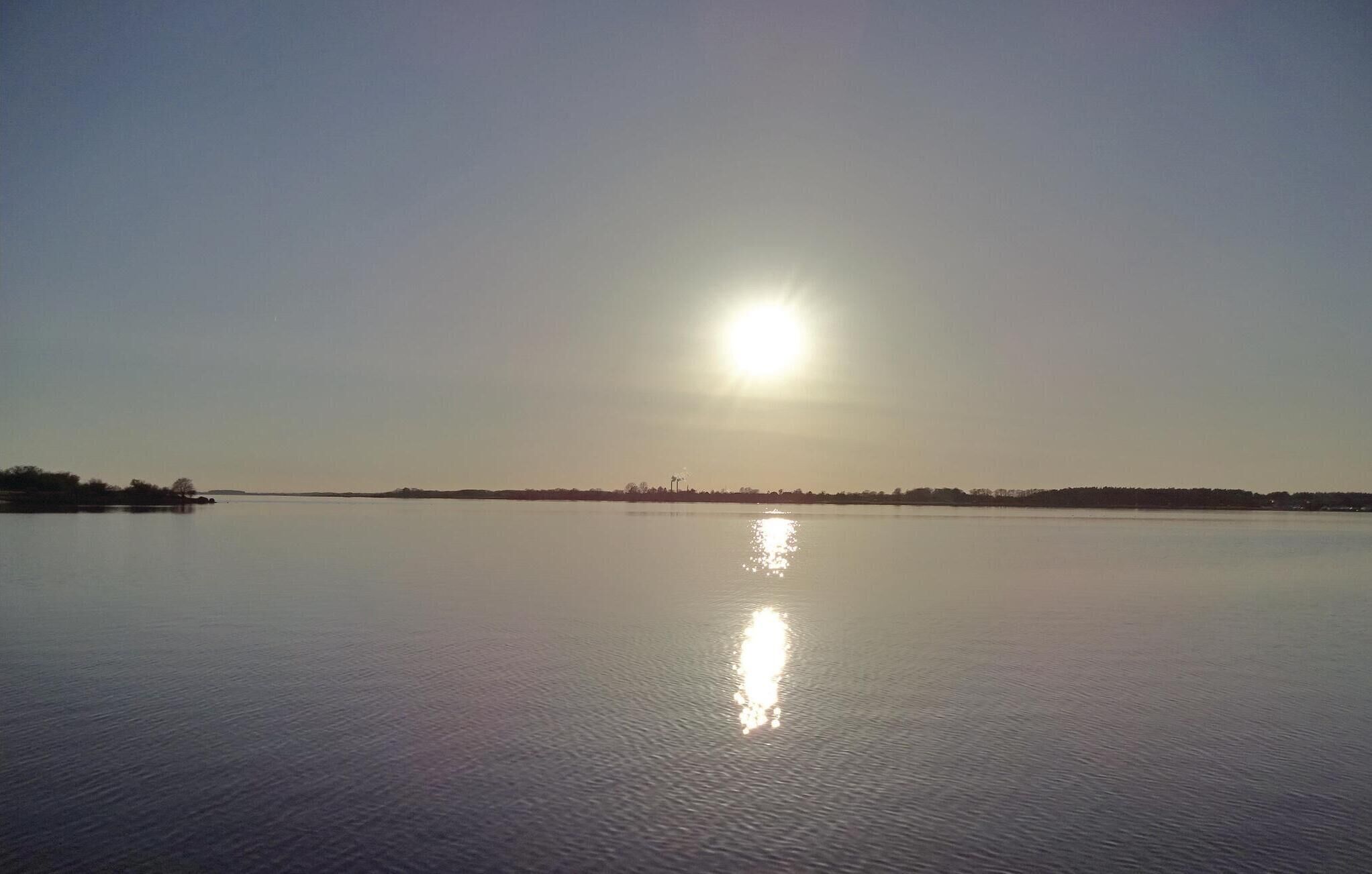 Ruhige Wasserfläche, die die Sonne spiegelt.
