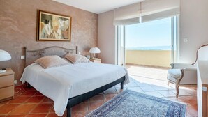 A bedroom with a bed, nightstands, a painting, a view through a large window, and a chair. - Lovely home in Sainte-Maxime with WiFi (Sainte-Maxime)