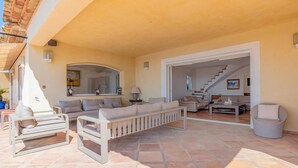 A spacious living area with a sofa set, a coffee table, and a dining table. There is a staircase leading to another level. - Lovely home in Sainte-Maxime with WiFi (Sainte-Maxime)