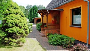Un chemin menant à un bâtiment doté d’un toit en tuiles et de murs orange.