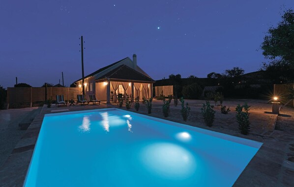A swimming pool at dusk with a house in the background. - Gorgeous home in Radonic (Radonic)