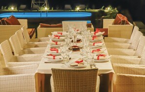 A dining table set for a meal with white tablecloths, red napkins, and clear glassware. - Beautiful home in Houdetsi,Heraklio (Houdetsi,Heraklio)
