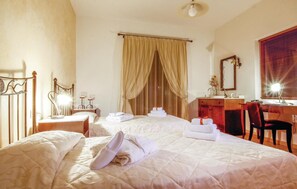 A hotel room with two beds, a desk, a chair, a mirror, and a window with blinds. - Beautiful home in Houdetsi,Heraklio (Houdetsi,Heraklio)
