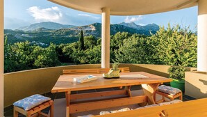 A wooden table and benches on a balcony with a mountain view. - Awesome apartment in Herceg Novi (Herceg Novi)