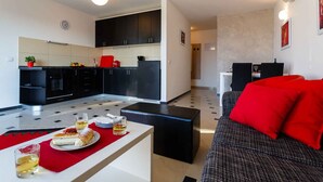 A modern apartment with a kitchen, dining area, and living room.