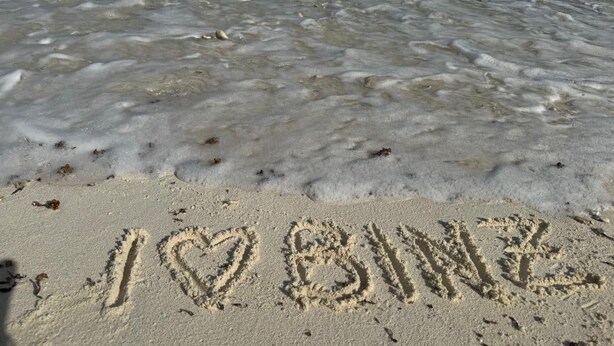 Una playa arenosa con las palabras "I ♥ BINGO" escritas en la arena.