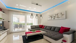 Un salon moderne avec un canapé d’angle, une table basse et un téléviseur.
