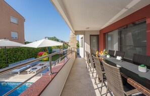 Un balcon avec piscine, un espace salon extérieur et un coin jeux pour enfants.