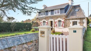 A stone house with a white picket fence, a number 7 sign, and a small garden. - 2 bedroom lovely home in Pleubian (Pleubian)