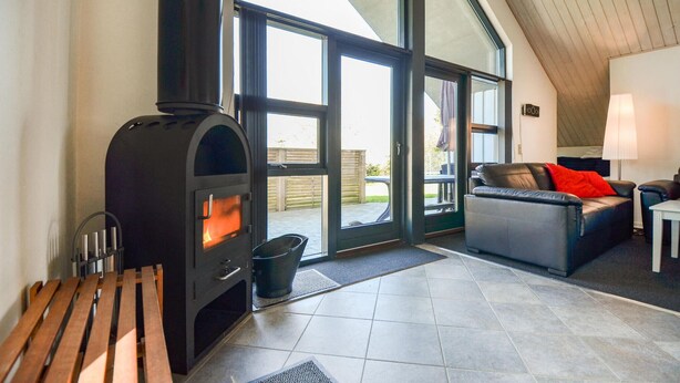 A modern living room with a wood-burning stove, a sofa, and a dining table. - 3 bedroom lovely home in Glesborg (Glesborg)