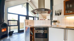 A modern kitchen with a built-in oven, a stove, and a large window. - 3 bedroom lovely home in Glesborg (Glesborg)