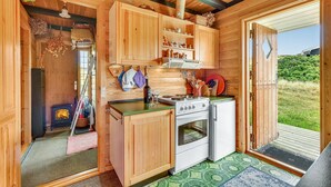 A compact kitchen with wooden cabinets, a stove, and a refrigerator.