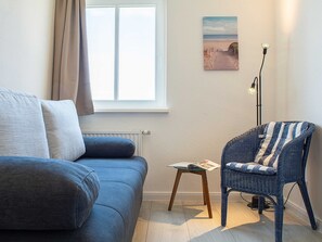 A living room with a sofa, a chair, a small table, a floor lamp, and a picture on the wall. - At the city forest Whg 15-14 .. - 15-14 (Kühlungsborn)