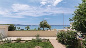 Un quartier résidentiel offrant une vue sur la mer, avec un chemin pavé et quelques espaces verts.