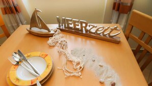 A table set with plates, cutlery, and a decorative sailboat. - (192) 2-room apartment lake view - Apartment house Baltic Sea beach (Kühlungsborn)
