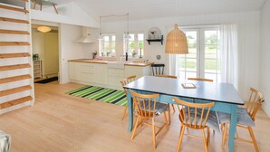 A bright kitchen with white cabinets, a wooden dining table, and chairs. - Gorgeous home in Sydals with WiFi (Sydals)