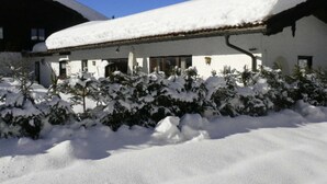 A building with a snow-covered roof and a snow-covered garden.