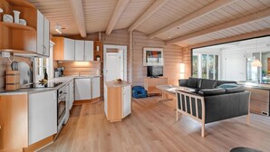 A modern log cabin interior with a kitchen, dining area, and living room. - Beautiful home in Farsø with kitchen (Farsø)