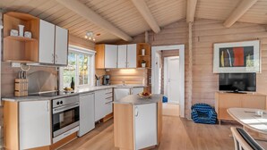 A modern kitchen with white and wooden cabinetry, a built-in oven, and a central island with a sink. - Beautiful home in Farsø with kitchen (Farsø)
