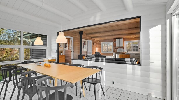 A modern kitchen with a large island, wooden cabinets, and a view into the living area. - Beautiful home in Farsø with kitchen (Farsø)