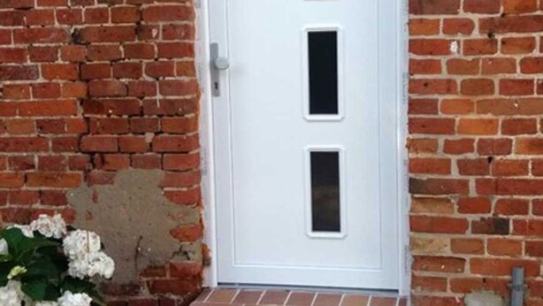 A white door with three rectangular windows. - Apartment 3 - Guesthouse Alte Schule (Schwarz)