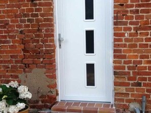 Una puerta blanca con tres ventanas rectangulares.