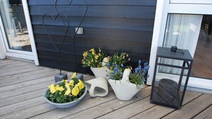 En træterrasse med plantekasser og en lygt.