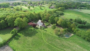 An aerial view of a rural property with a large house, multiple barns, and extensive green fields. - Hof Sonnengold (Osterholz-Scharmbeck)