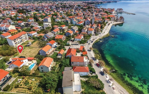 An aerial view of a coastal town with red-roofed houses, a marina, and clear blue waters. - Amazing home in Kastel Stafilic (Kastel Stafilic)