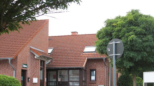 En murbygning med tegltag, et skilt der siger 'Empfang', og et forbudsskilte mod parkering.
