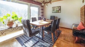 A dining area with a wooden table, black chairs, and a patterned rug. - Stunning apartment in Hinterweidenthal (Hinterweidenthal)