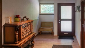 A hallway with a wooden bench, a door with a window, and a radiator. - Stunning apartment in Hinterweidenthal (Hinterweidenthal)