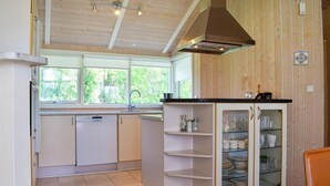 A kitchen with a dishwasher, a sink, and a cabinet with glass doors. - Stunning home in Gilleleje with kitchen (Gilleleje)