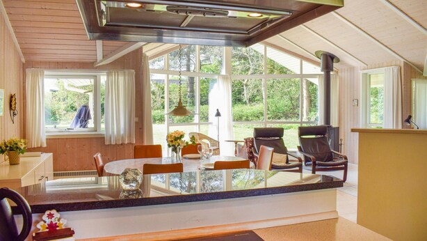 A modern kitchen with a central island, large windows, and a dining area with chairs. - Stunning home in Gilleleje with kitchen (Gilleleje)