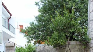 A stone barbecue area with a stone wall and greenery.