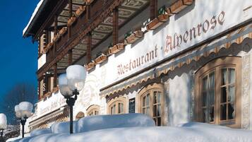 Een traditioneel gebouw met een bord waarop 'Restaurant Alpenrose' staat.