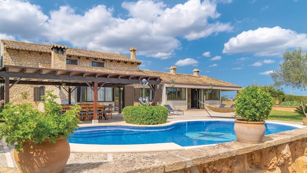 A stone villa with a swimming pool, outdoor seating, and a covered patio. - Lovely home in Muro with private swimming pool, can be inside or outside (Muro)
