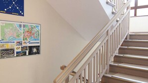 A staircase with a wooden handrail and beige carpeted steps. - Labedz (LA16) - LA16 (Swinoujscie)