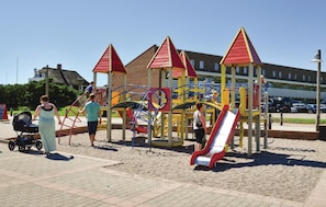 Children can play on the slide and climbing elements in this outdoor playground.
